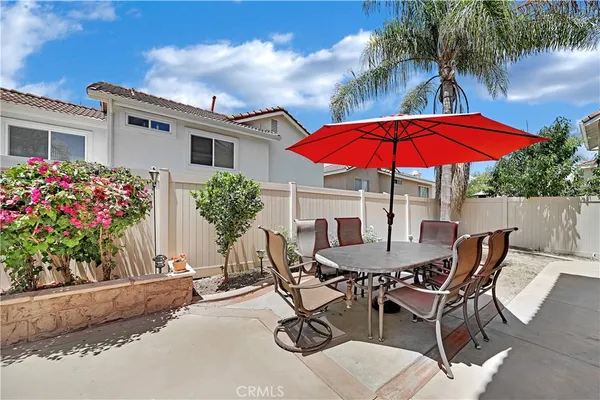 a view of a patio with table and chairs under an umbrella