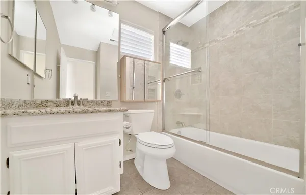 a bathroom with a sink toilet vanity and shower