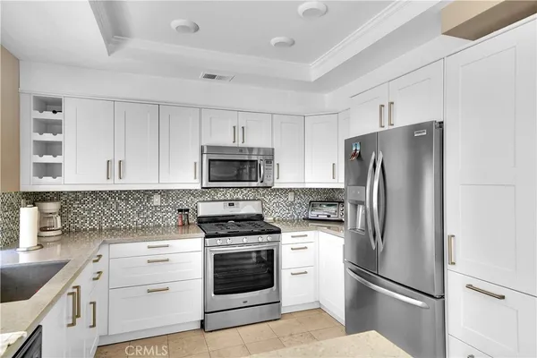 a kitchen with stainless steel appliances a refrigerator stove and white cabinets