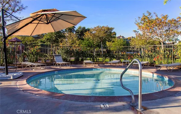 a view of a swimming pool with a bench and fire pit