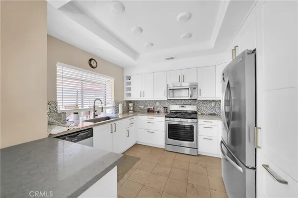 a kitchen with stainless steel appliances granite countertop a refrigerator sink and stove