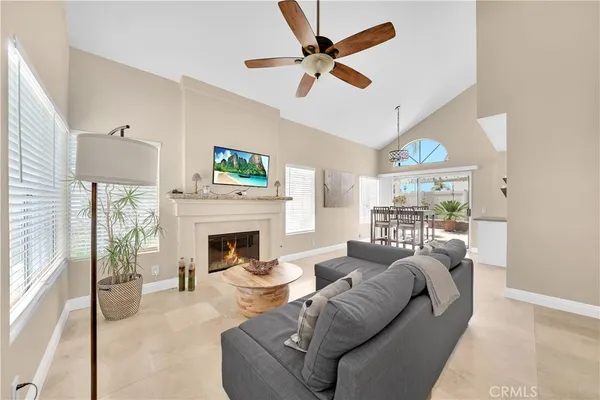 a living room with furniture a fireplace and a large window