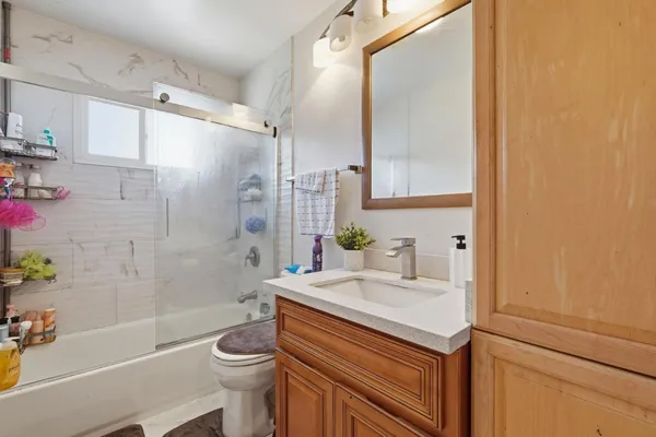 a bathroom with a sink a toilet and shower
