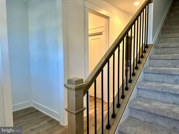 a view of staircase with wooden floor and white door