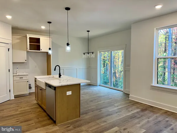 a kitchen with stainless steel appliances granite countertop a sink a stove and a wooden floors