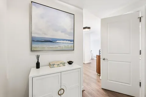 a hallway with view of wooden floor and mirror