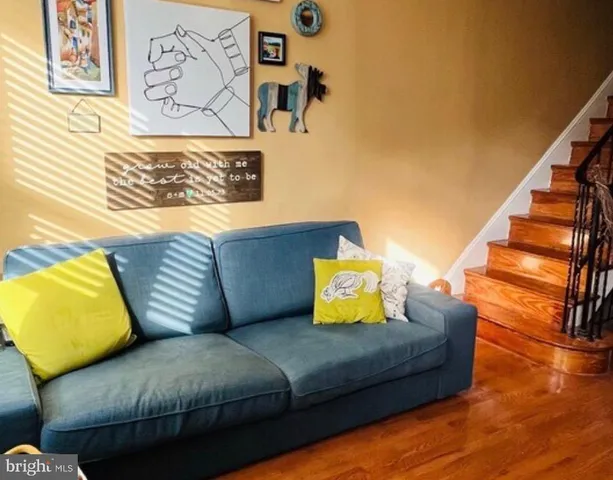 a living room with couch and a wooden floor