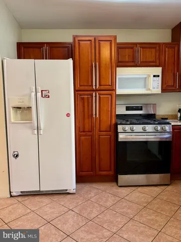 a white refrigerator freezer and a stove sitting inside of a kitchen