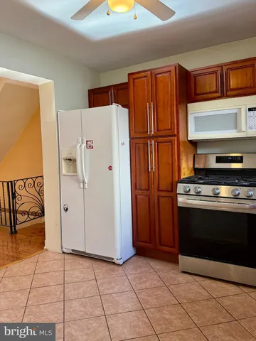 a view of kitchen with stainless steel appliances granite countertop a refrigerator and a stove top oven