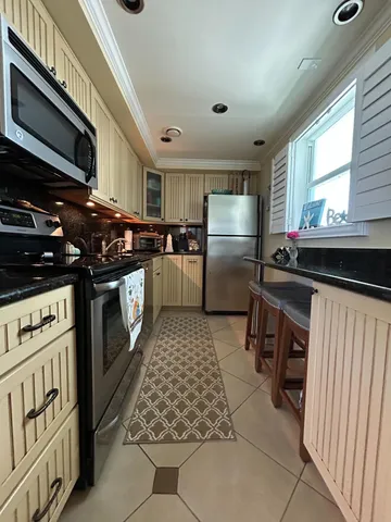 a kitchen with a stove a refrigerator and cabinets