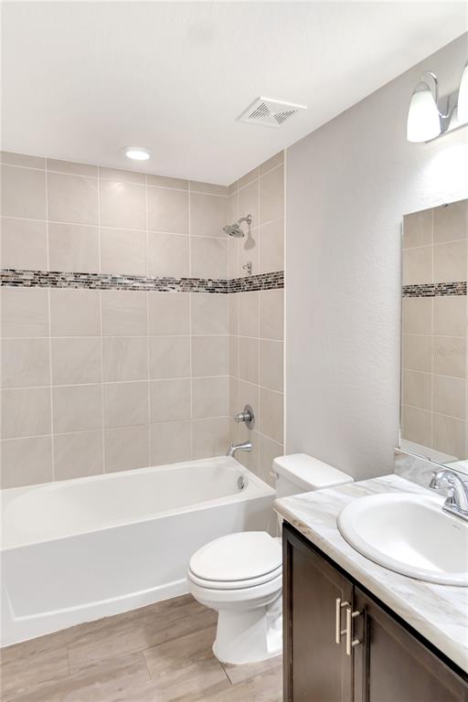 961 Inverness Way Lake Lake Alfred, FL 33850 - Photo 14 of 22 a bathroom with a granite countertop sink a toilet and bathtub