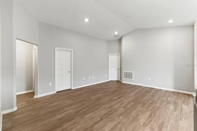 a view of an empty room with wooden floor