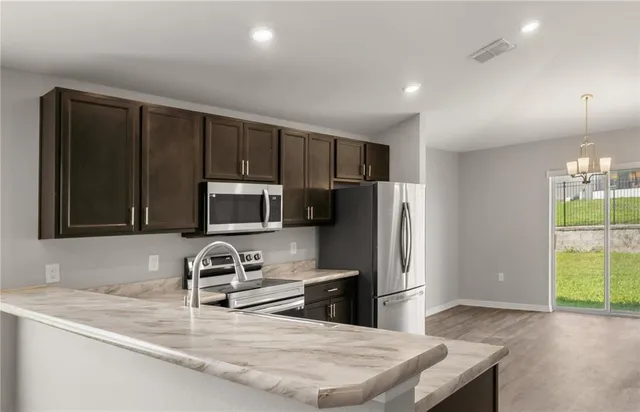 a kitchen with stainless steel appliances granite countertop a sink refrigerator and microwave