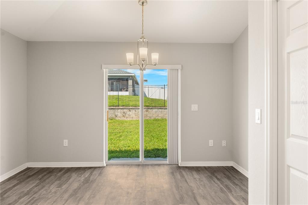 961 Inverness Way Lake Lake Alfred, FL 33850 - Photo 6 of 22 a view of an empty room with a window and wooden floor