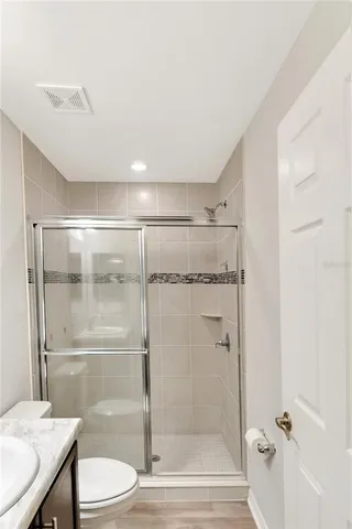 a bathroom with a granite countertop bathtub sink vanity mirror and toilet