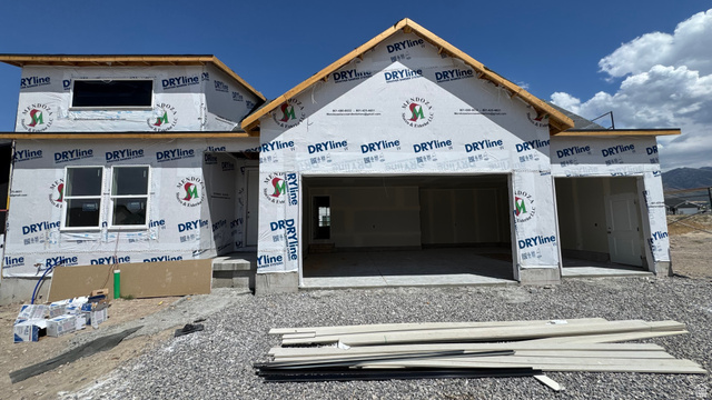 1862 Mantle Way, Unit 418 Tooele, UT 84074 - Photo 2 of 10 New construction home featuring a two-car garage, an additional single-car garage, multiple white-framed windows, and a prominent gable roofline