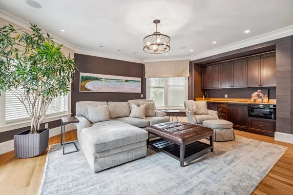 a living room with furniture a chandelier and a flat screen tv