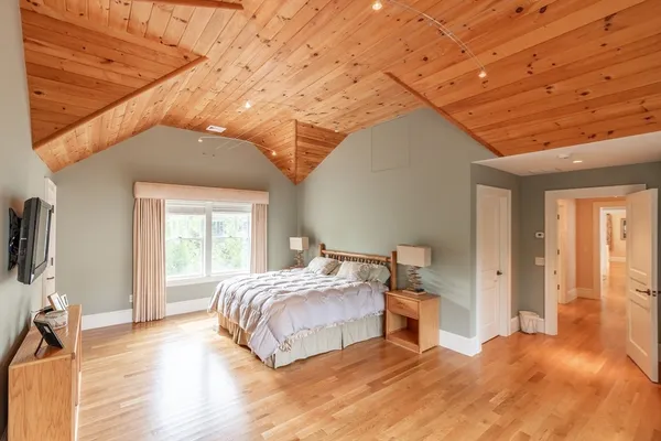 a bedroom with a bed and a flat tv screen on wall