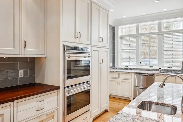 a kitchen with granite countertop white cabinets and white appliances