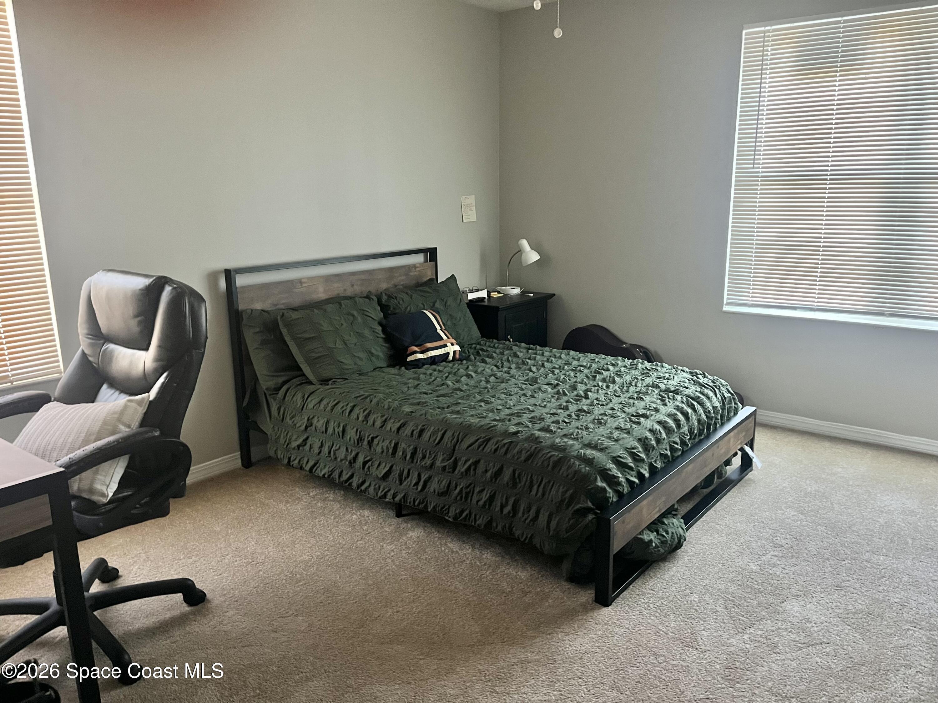 7667 North Wickham Road, Unit 1118 Melbourne, FL 32940 - Photo 12 of 26 a bedroom with a bed chair and window