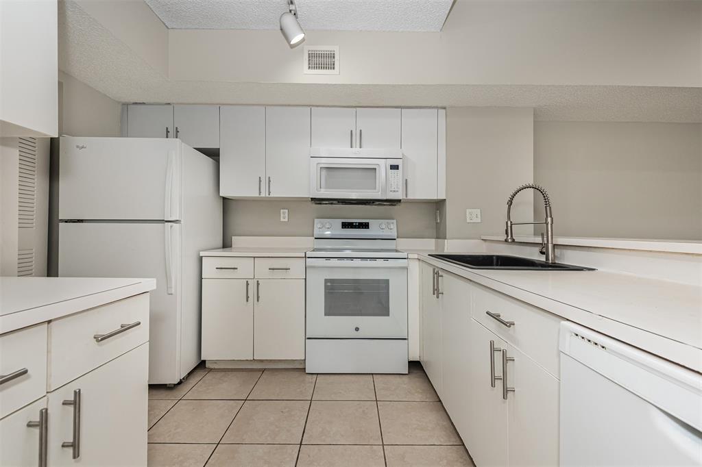 3848 Lyons Road, Unit 202 Coconut Creek, FL 33073 - Photo 13 of 32 a kitchen with cabinets appliances a sink and a stove