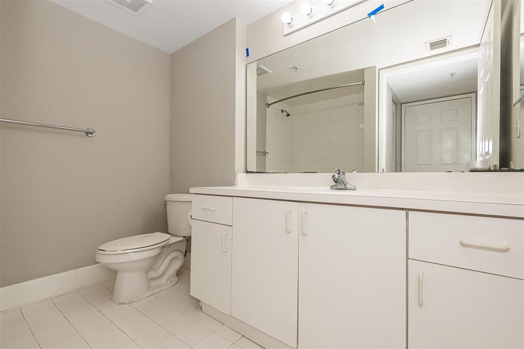 3848 Lyons Road, Unit 202 Coconut Creek, FL 33073 - Photo 20 of 32 a bathroom with a toilet sink and mirror