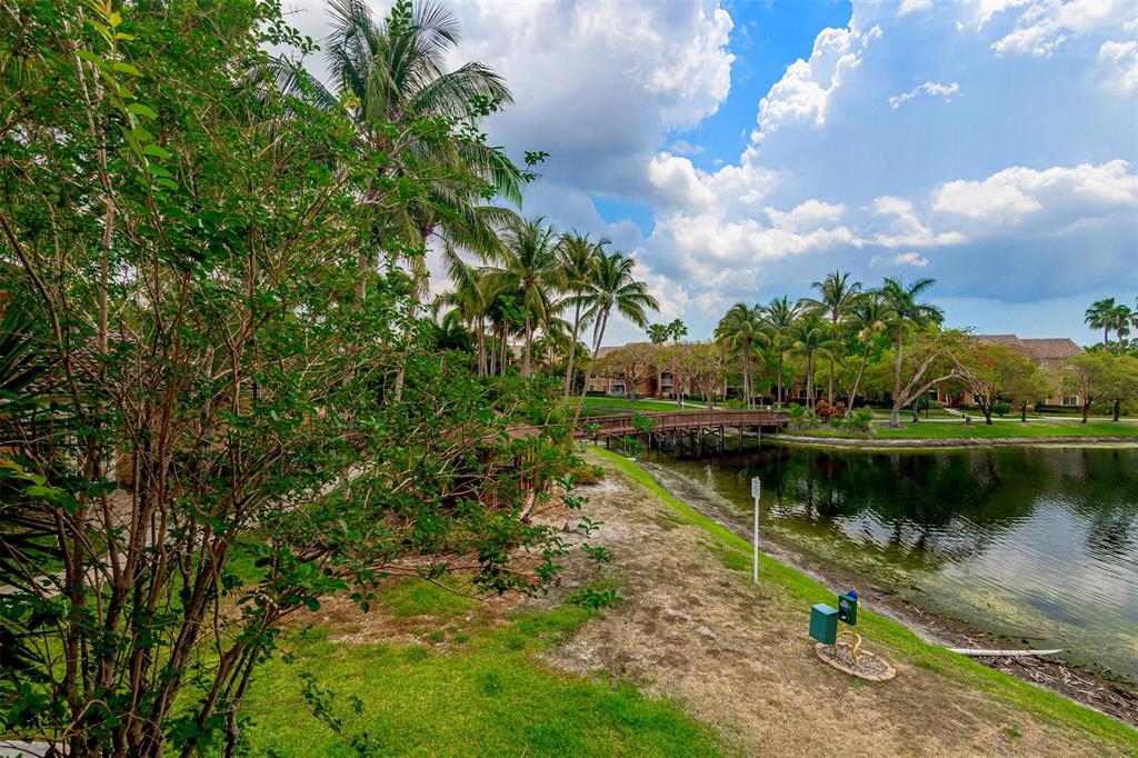 3848 Lyons Road, Unit 202 Coconut Creek, FL 33073 - Photo 30 of 32 a view of a lake with a house in the background