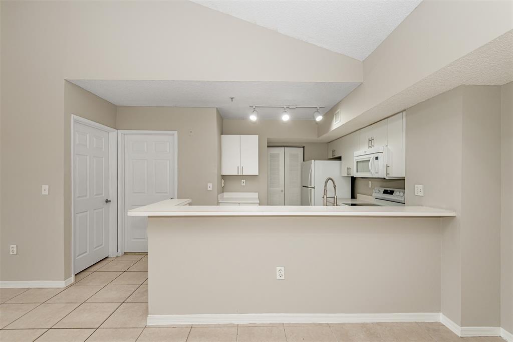 3848 Lyons Road, Unit 202 Coconut Creek, FL 33073 - Photo 10 of 32 a large white kitchen with a sink and cabinets