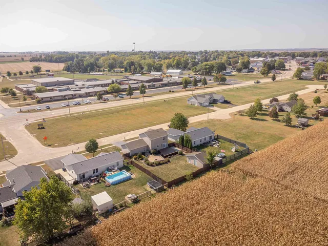 an aerial view of ocean and residential houses with outdoor space