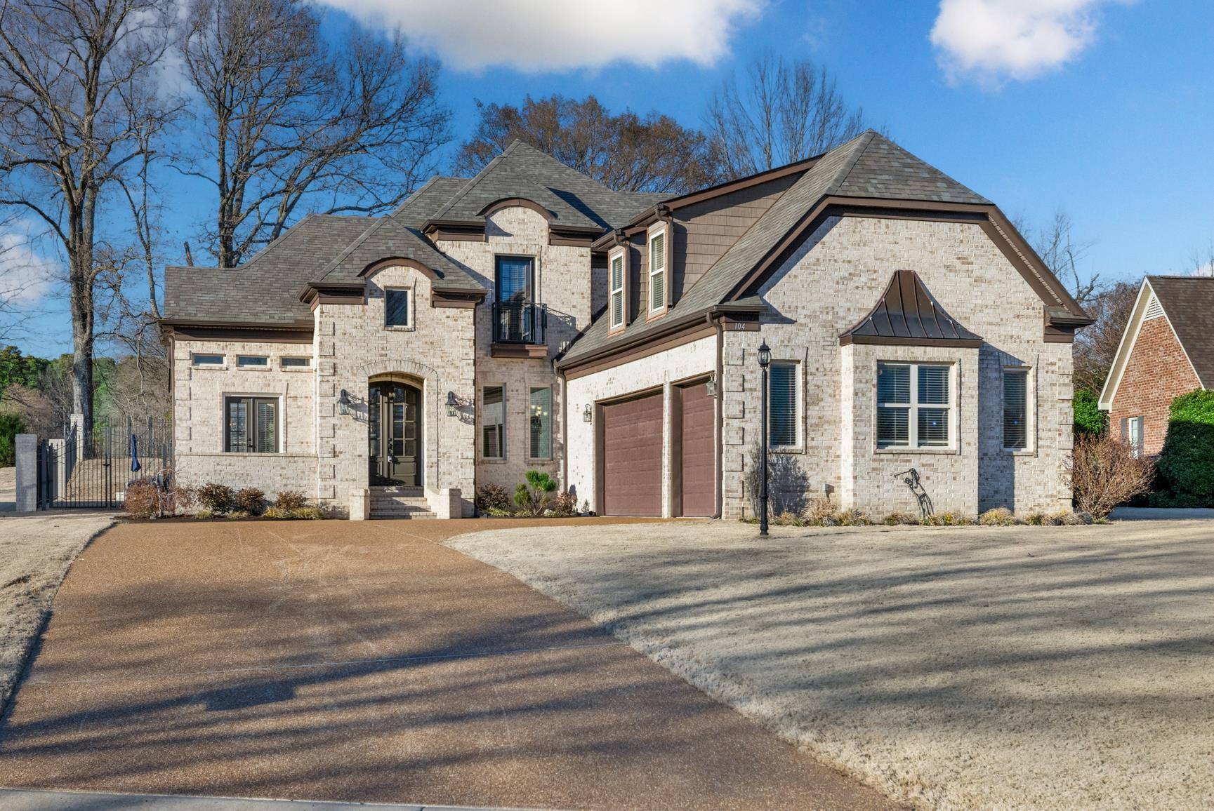 French country home with driveway, a garage, a shingled roof, and brick siding
