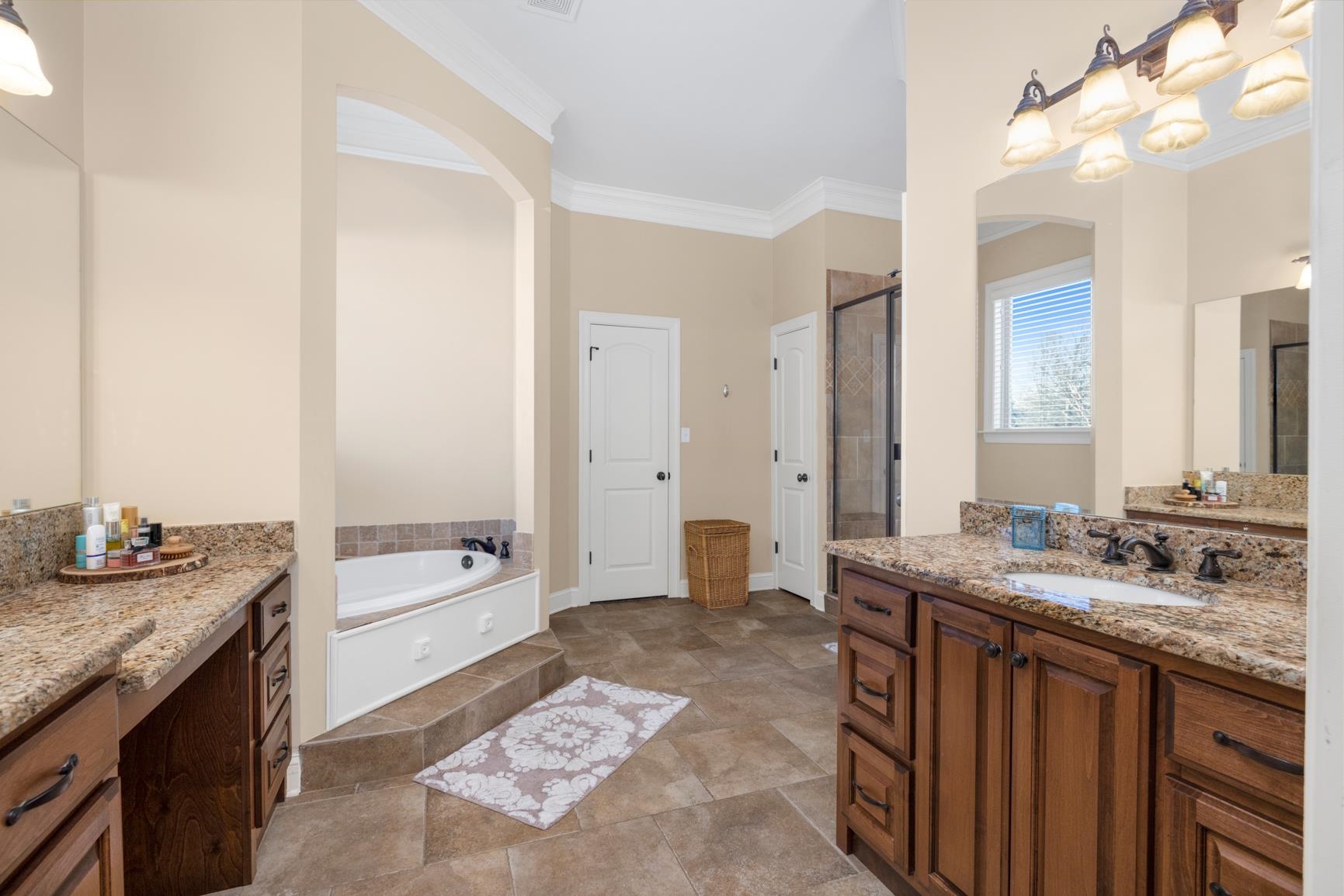 104 Eagle Trace Road Covington, TN 38019 - Photo 30 of 40 Bathroom with two vanities, ornamental molding, a bath, and a stall shower