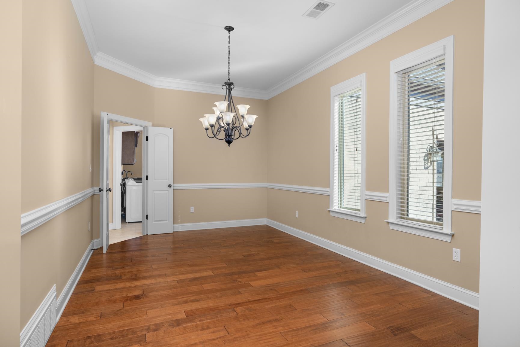 104 Eagle Trace Road Covington, TN 38019 - Photo 9 of 40 Unfurnished room with a chandelier, crown molding, dark wood finished floors, and washer / clothes dryer