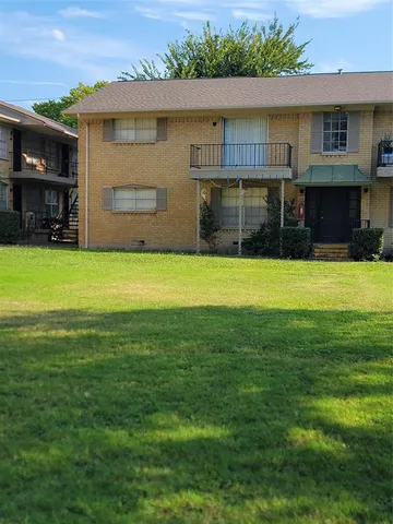 a view of a house with a garden and a table and chairs