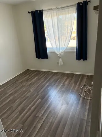 an empty room with wooden floor and entrance