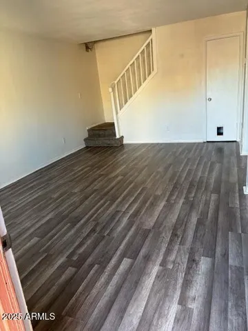a view of a hallway with wooden floor and stairs