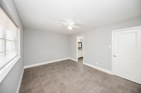 an empty room with closet and a ceiling fan