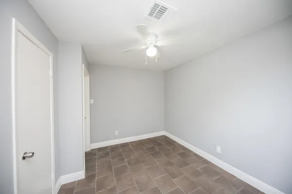 an empty room with a ceiling fan and a window