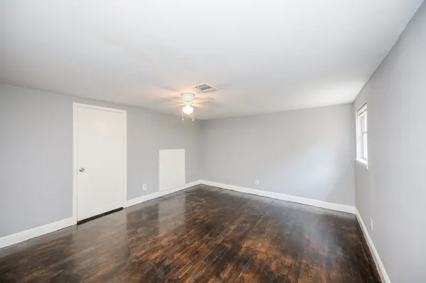 a view of an empty room with wooden floor