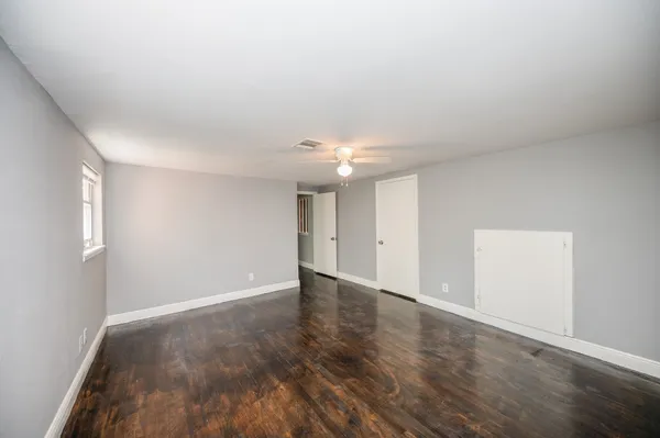 a view of an empty room with wooden floor