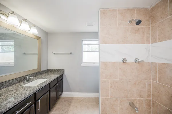 a bathroom with a granite countertop sink and a mirror