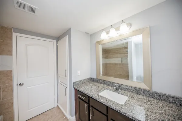 a bathroom with a granite countertop sink and a mirror