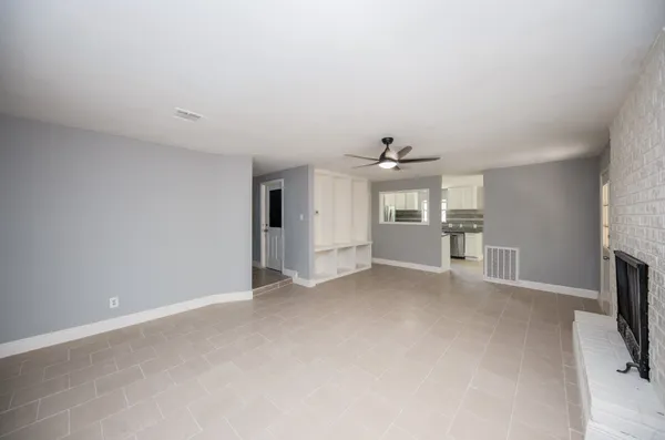 an empty room with fireplace and windows