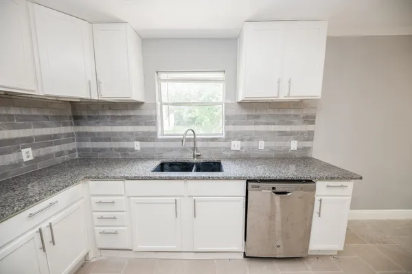 a kitchen with granite countertop a sink and a white stainless steel appliances