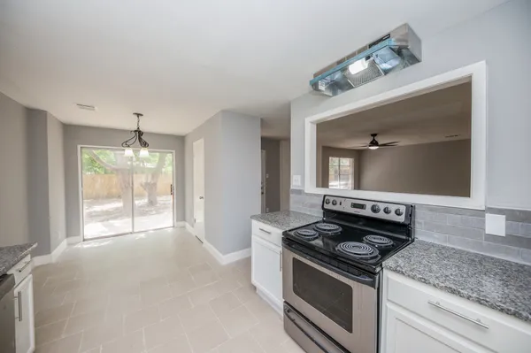 a kitchen with a stove and a wooden floor