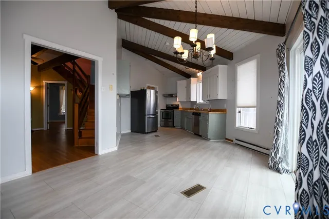 a view of a kitchen with stainless steel appliances wooden floor and chandelier