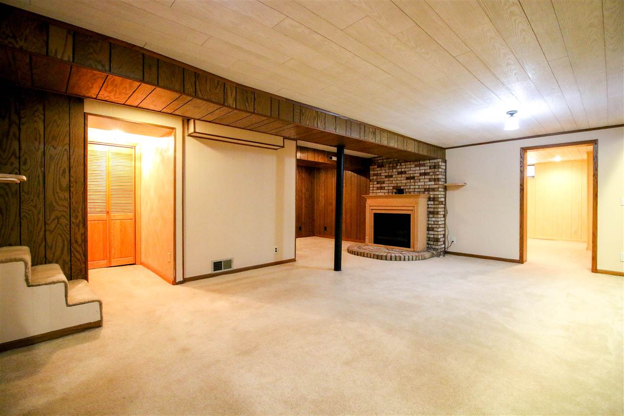 14031 South Bluff Road Rockton, IL 61072 - Photo 22 of 38 a view of an empty room with a fireplace and a window