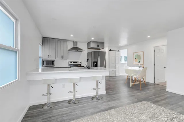 a open kitchen with white cabinets and stainless steel appliances