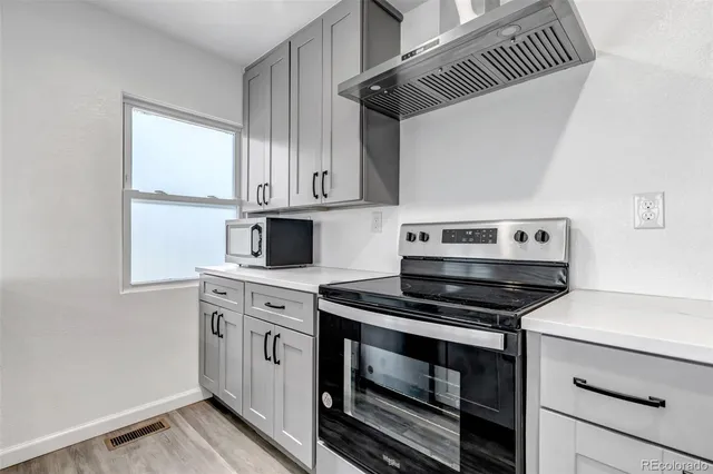 a kitchen with stainless steel appliances granite countertop a stove and a microwave