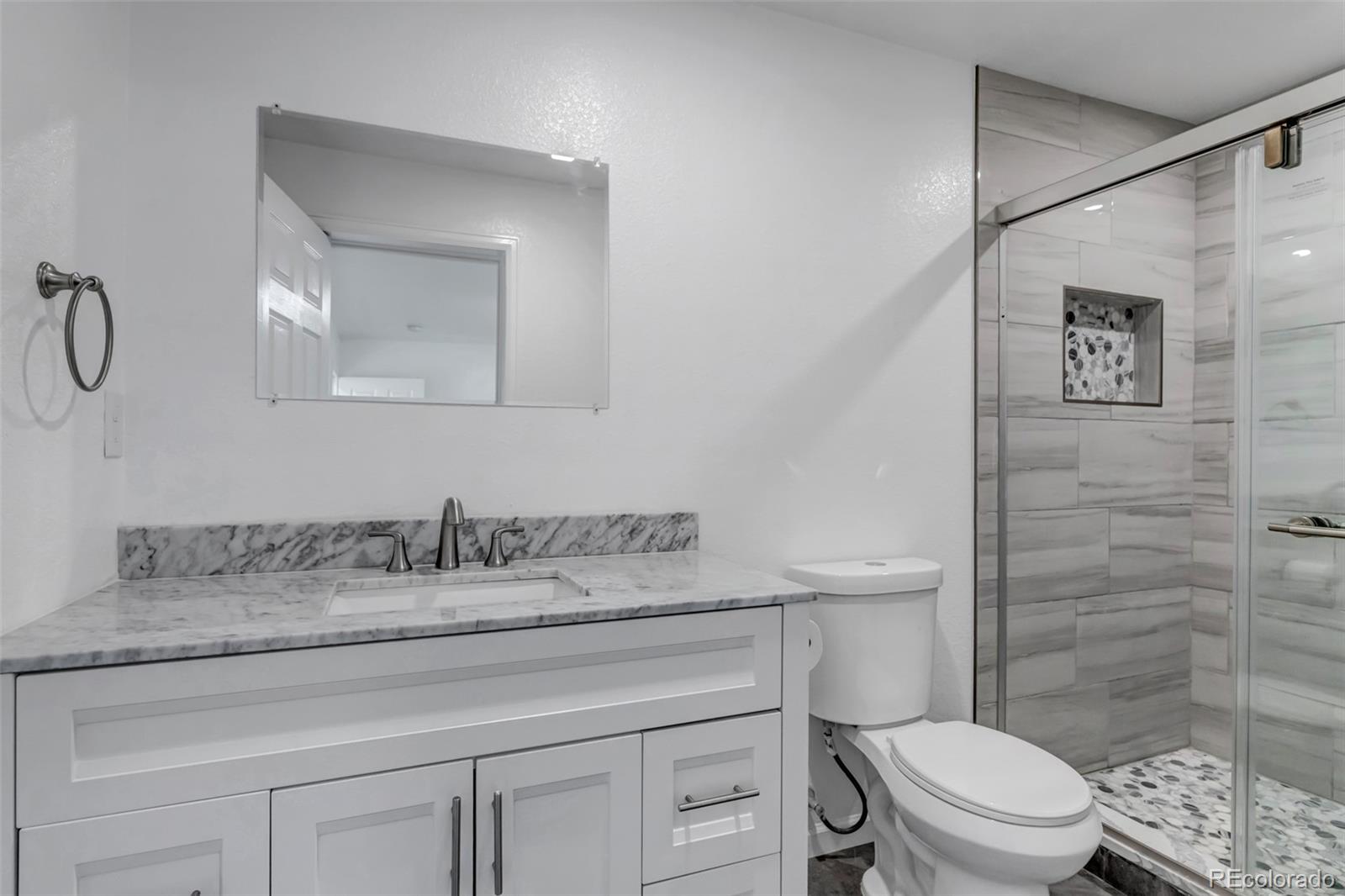10 South Irving Street Denver, CO 80219 - Photo 24 of 35 a bathroom with a granite countertop toilet sink and a mirror