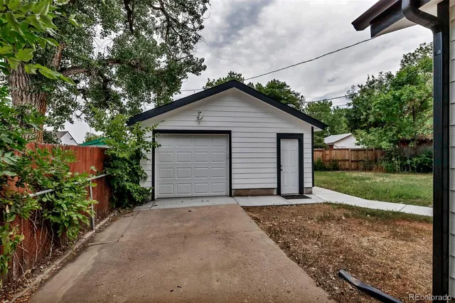 a view of a house with a small yard and garage